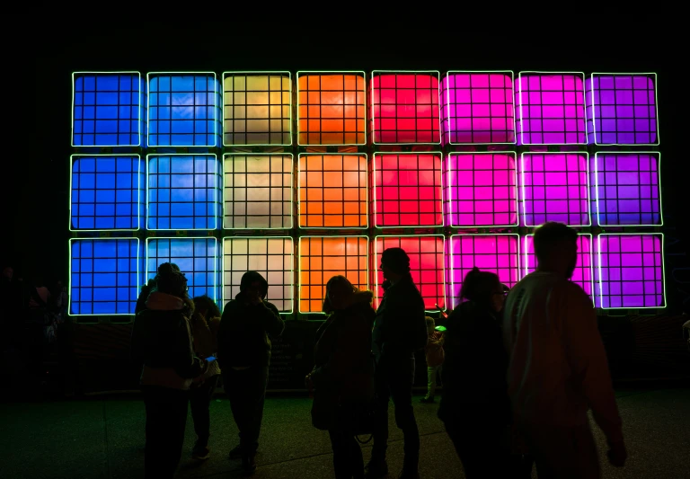 a colorful wall with squares of lights behind it