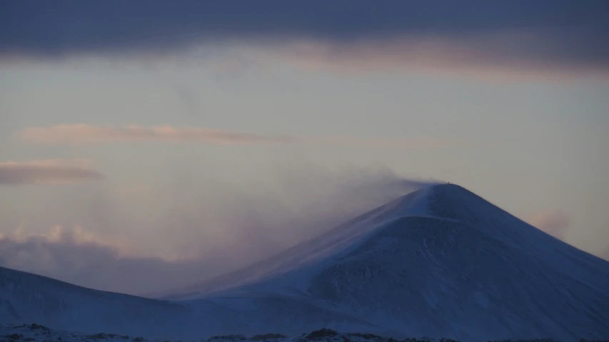 the mountain is covered with clouds in the daytime