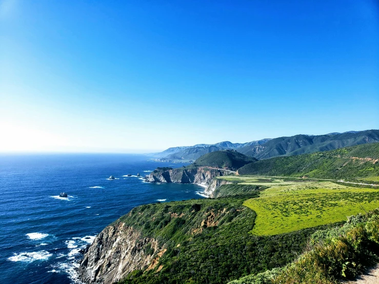 an open road leads to the ocean and another stretch of land is on the edge