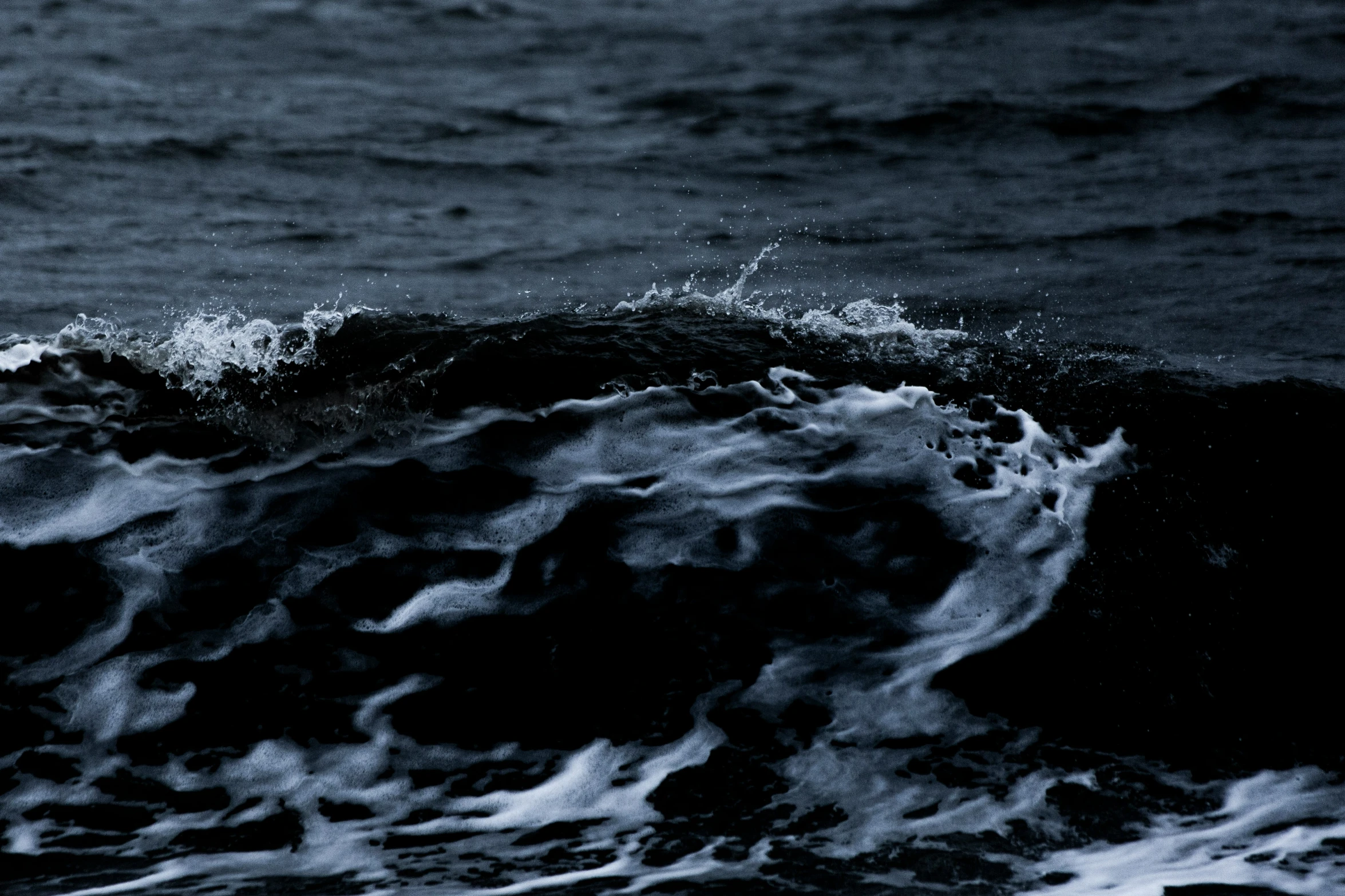 an ocean wave with a surfer in the back ground