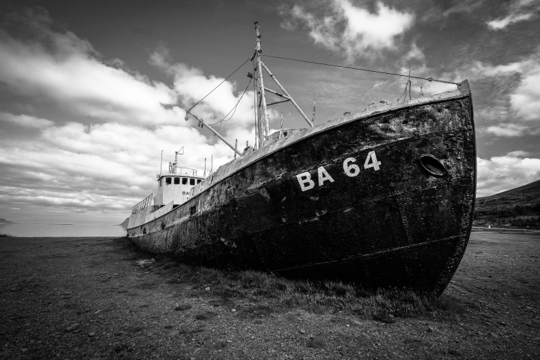 an old fishing boat that is sitting in the sand