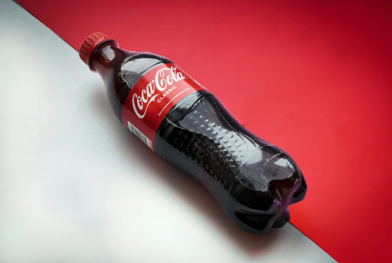 a bottle of coke on a white and red table