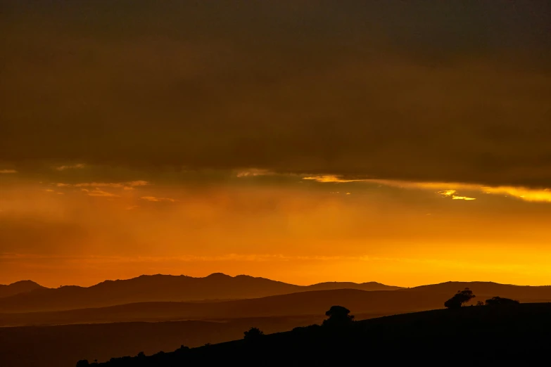 a mountain range with a bird silhouetted in the sunset