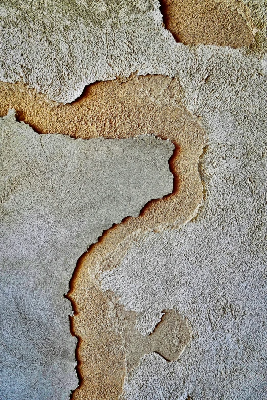 a wall covered in sand with some dirt