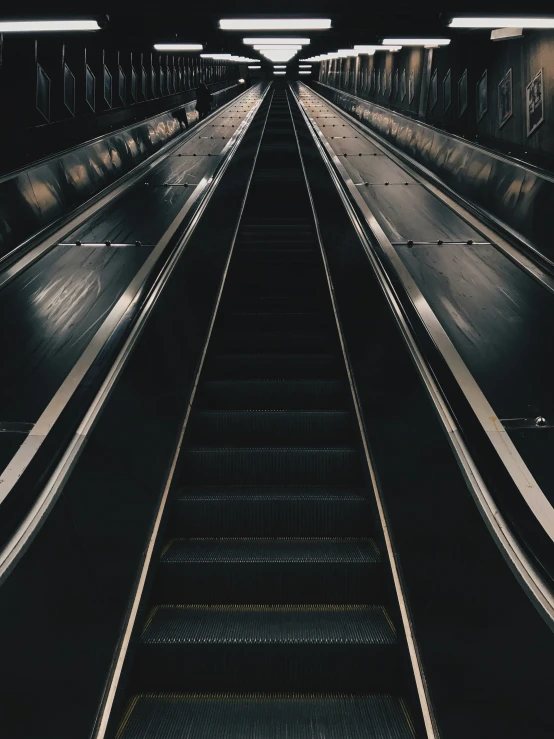 an escalator s looking down the way to someone's feet