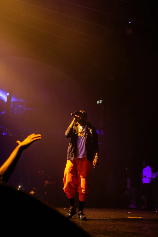 a person on stage with his hands out