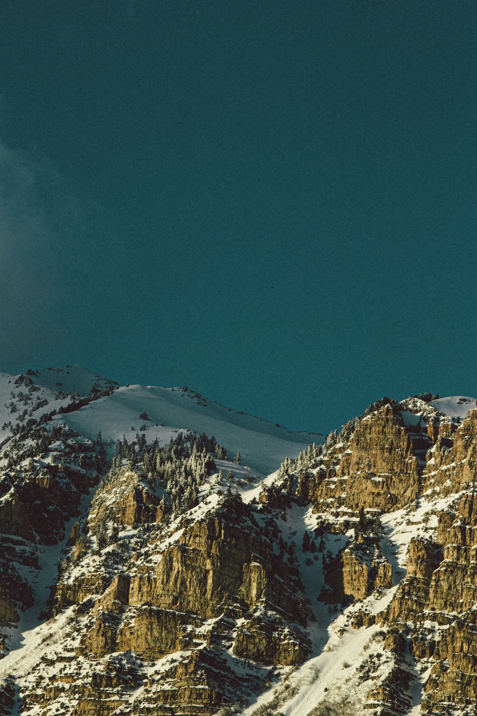 a full moon in the sky above mountains covered with snow