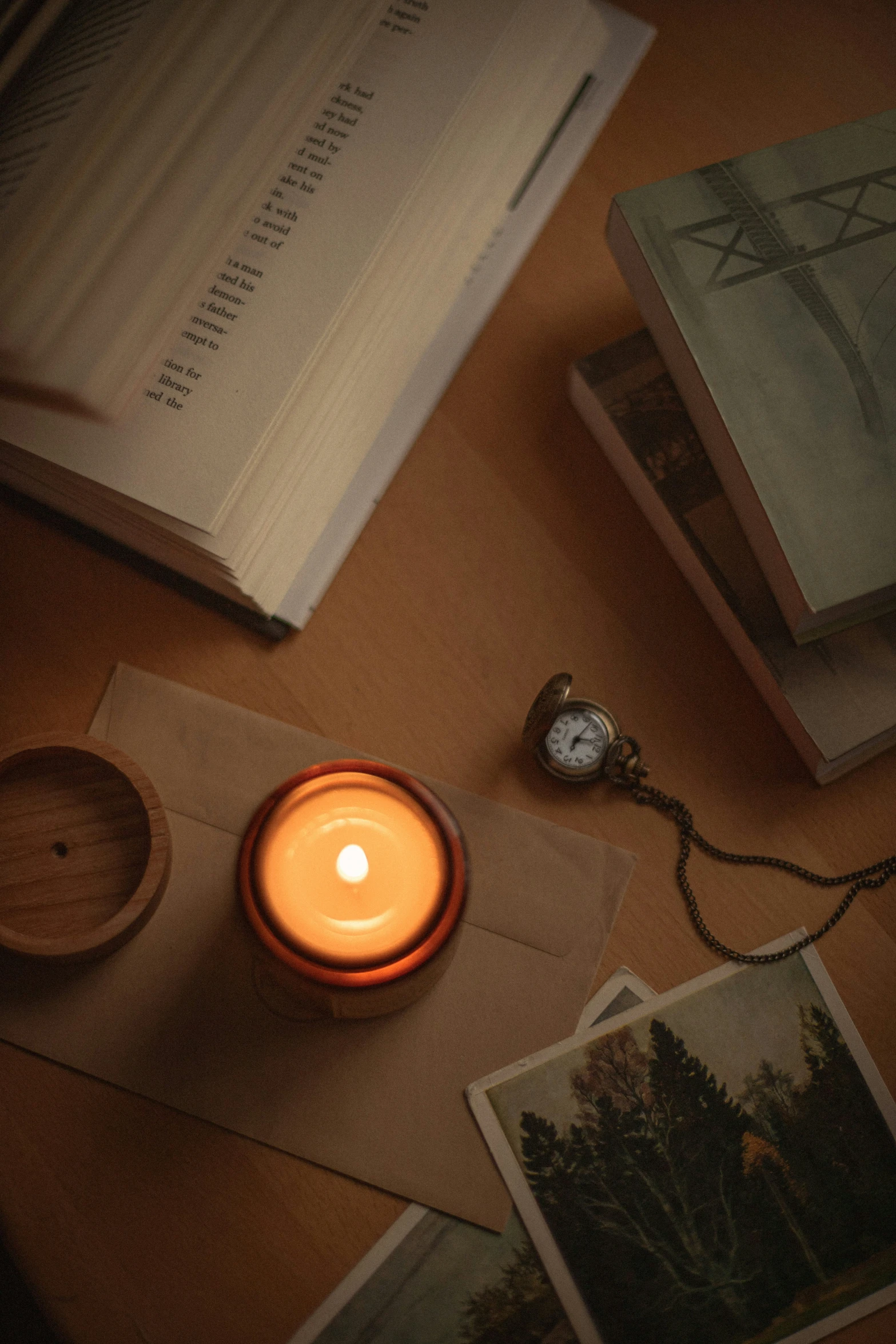 a lit candle sitting on top of a table next to books