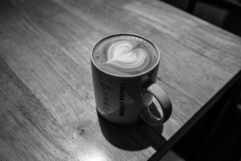 black and white pograph of coffee cup with latte art