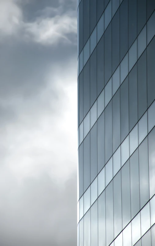 a building that has many windows with a cloudy sky