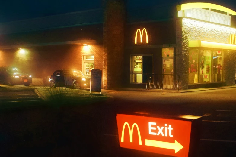 a lit up mcdonalds at night with a red sign