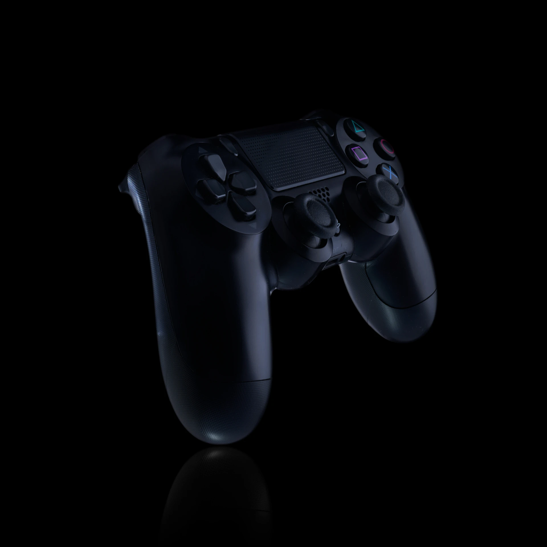 two controllers facing each other on the same side of a black surface