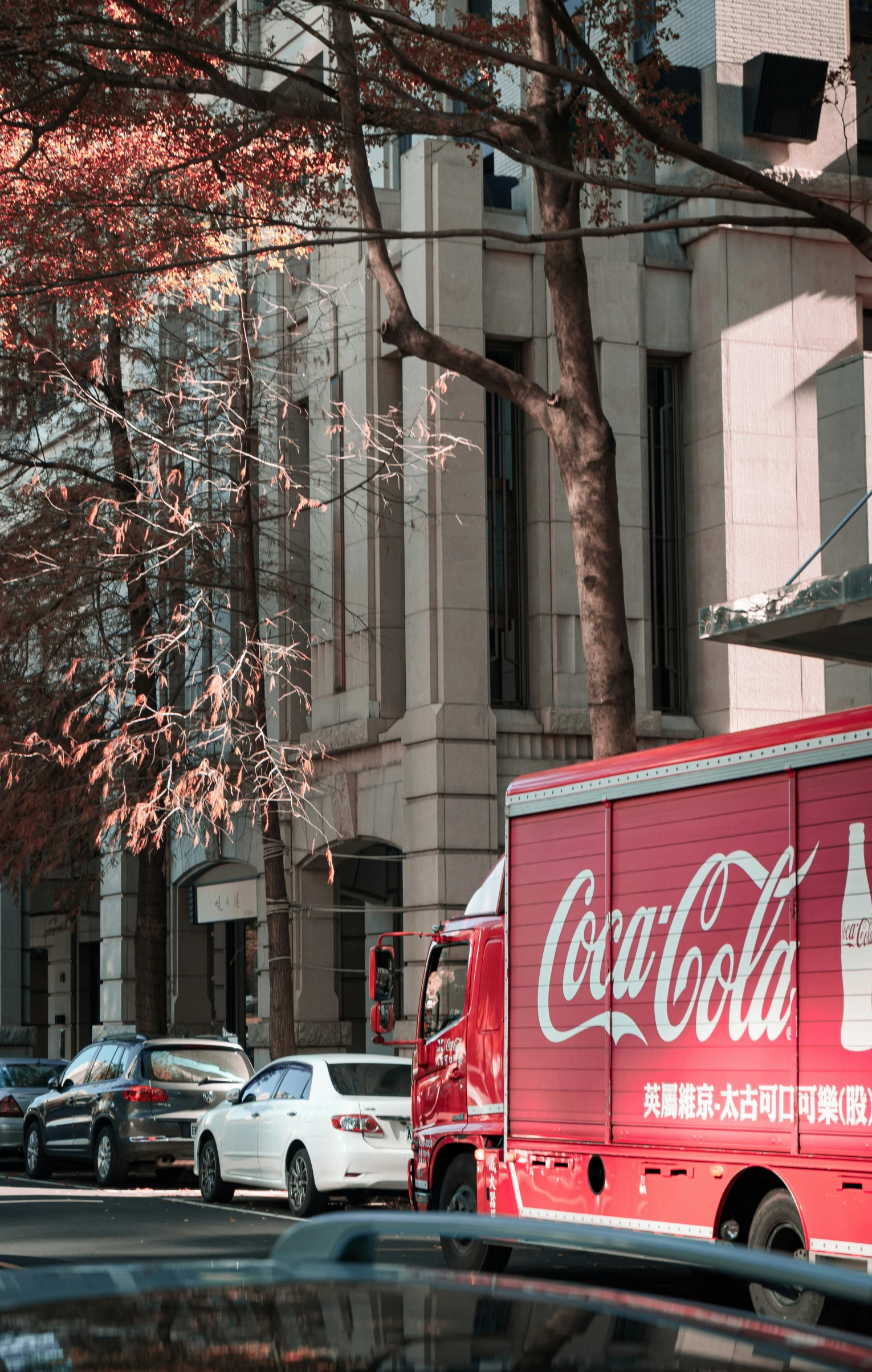 this coca cola delivery truck is parked on the side of the road