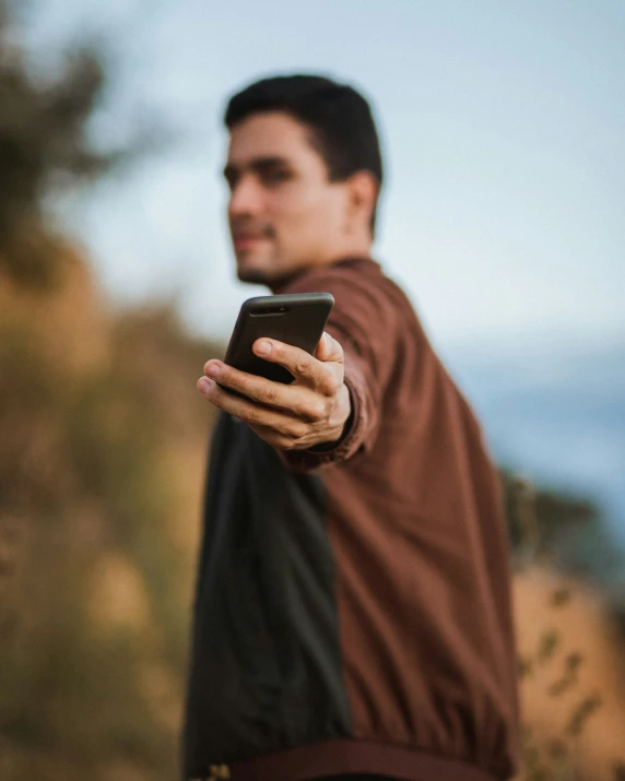 man standing in an area holding a phone