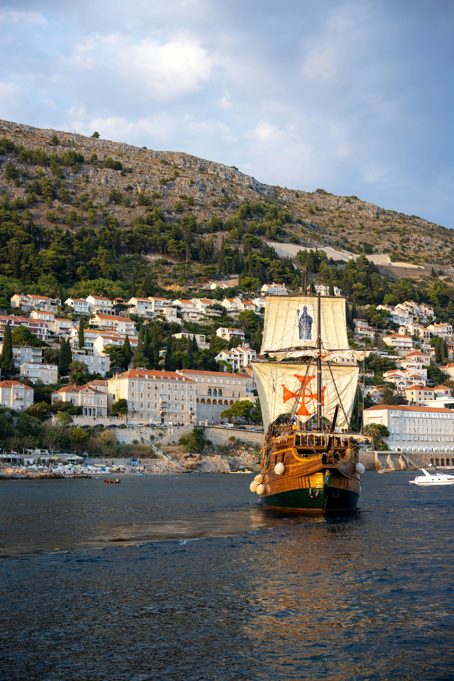 a boat sailing on top of a river next to a city