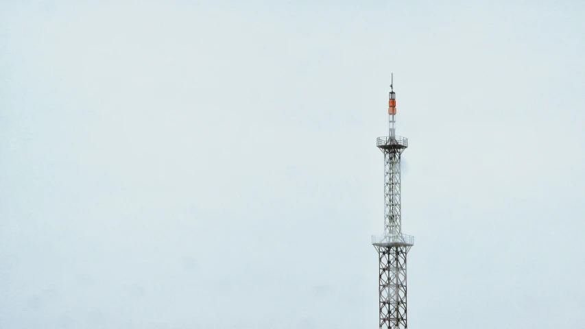 a tall radio tower with a red antenna on top