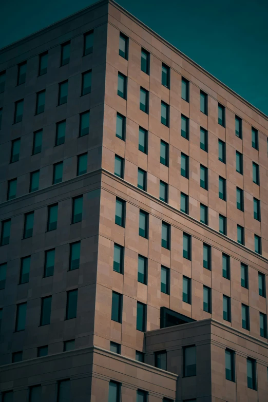 a tall brick building with windows and dark sky