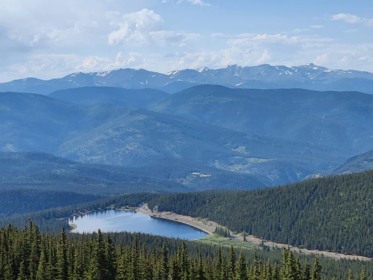 a beautiful mountain view with a body of water and a forest