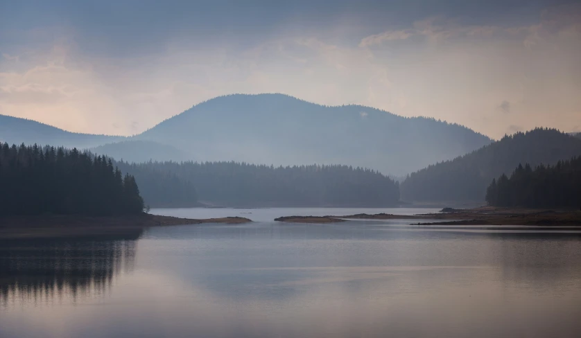 a mountain lake with many trees around it