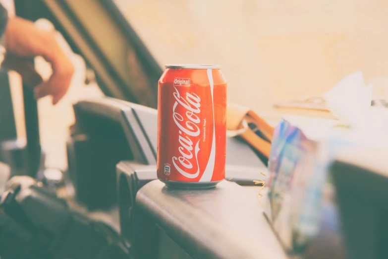 a coca cola can sits on the top of a chair