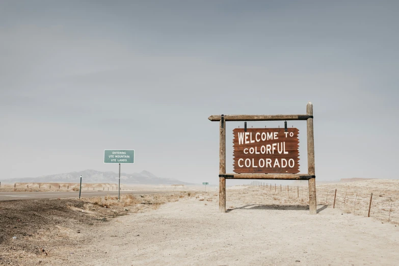 a welcome sign and a highway sign in the desert