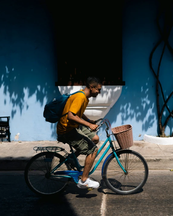 a man with a backpack riding his bike down the street