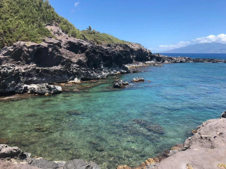 the blue water is crystal clear by the rocky cliffs