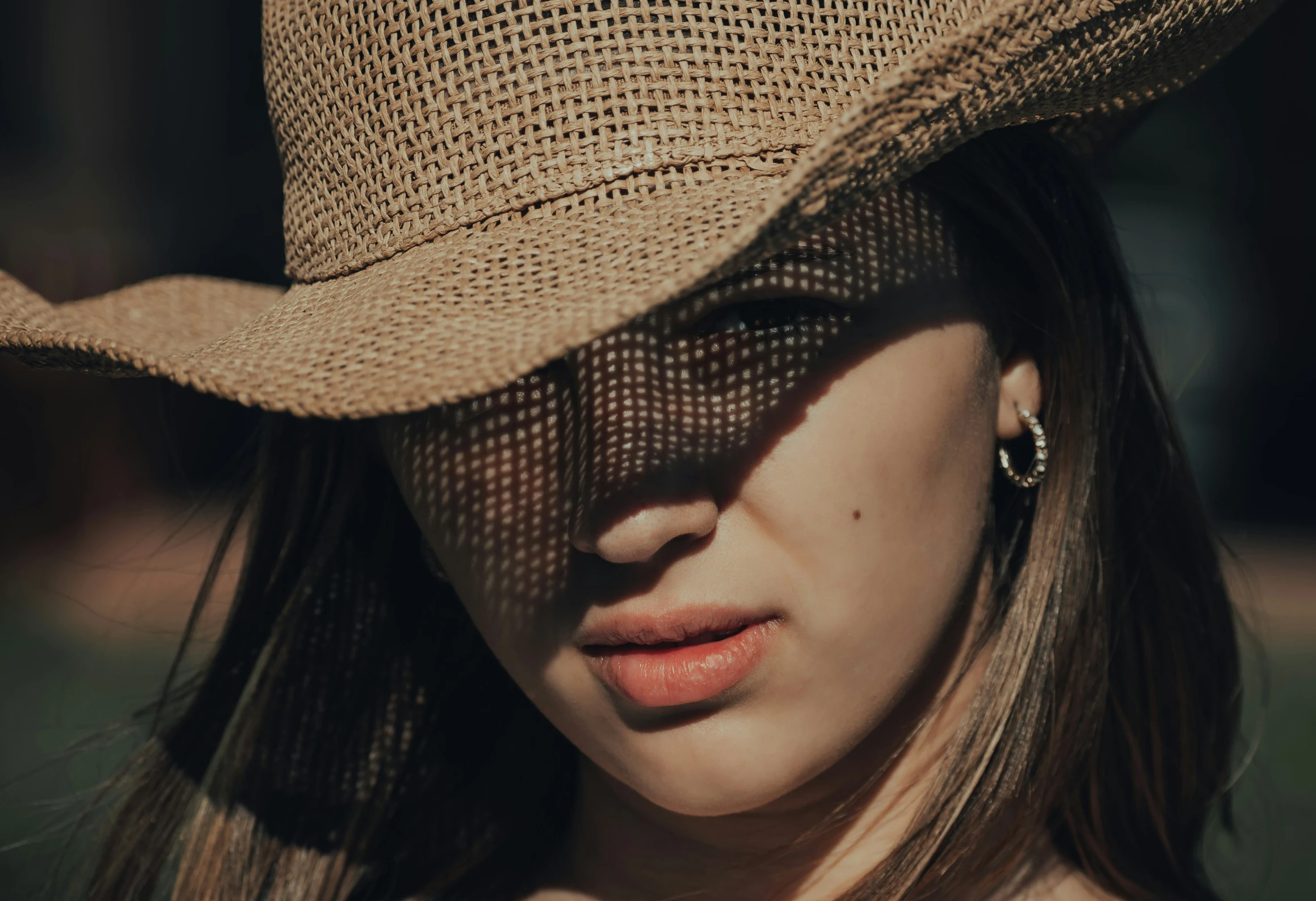 a woman with long hair wearing a tan hat