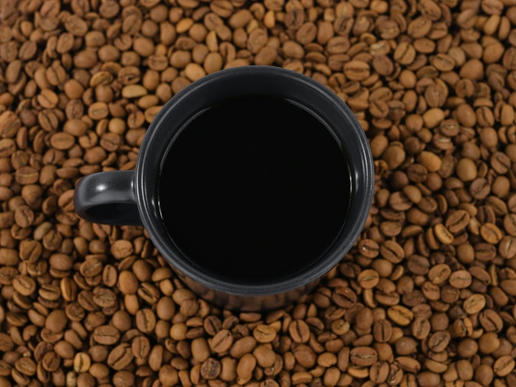 a cup that is inside of some coffee beans