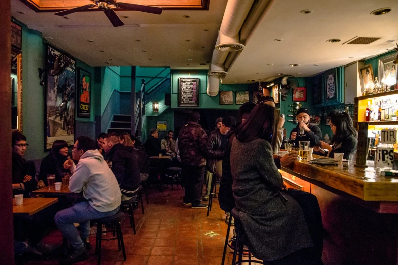 a group of people sit around drinking at an open bar