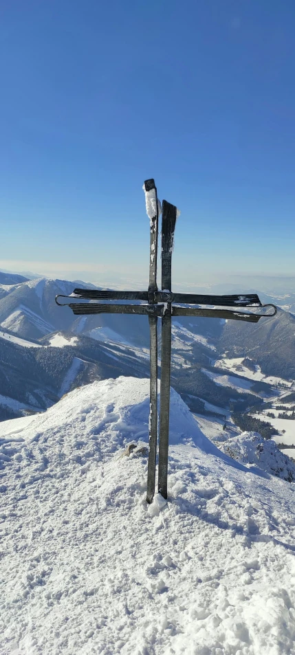 two snow skis are propped up on the side of a hill