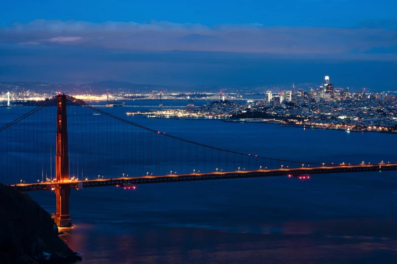 a bridge lit up and overlooking the city