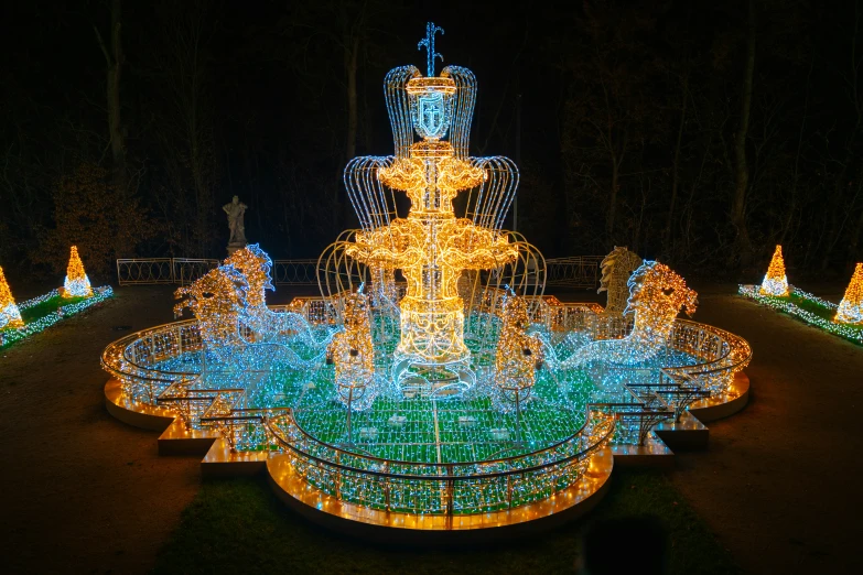 lights adorn this fountain in the park at night