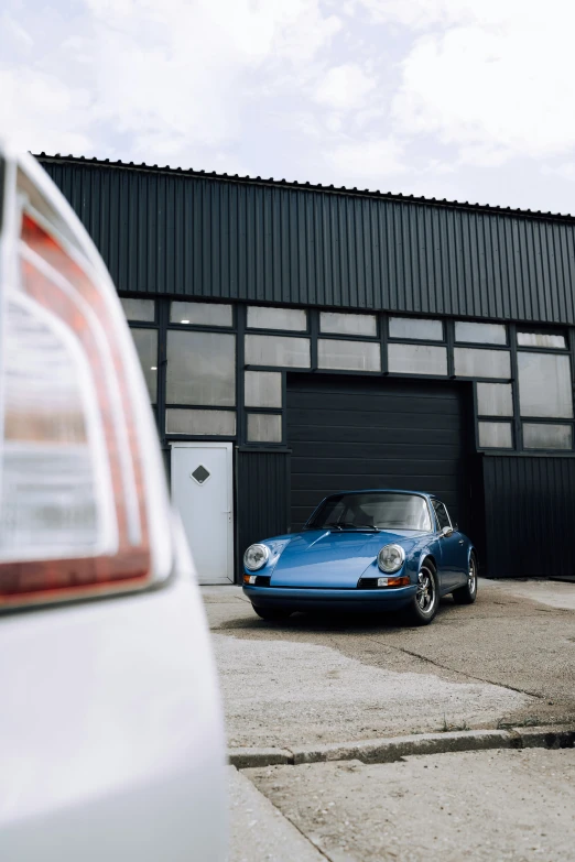 a blue car sitting next to a large building