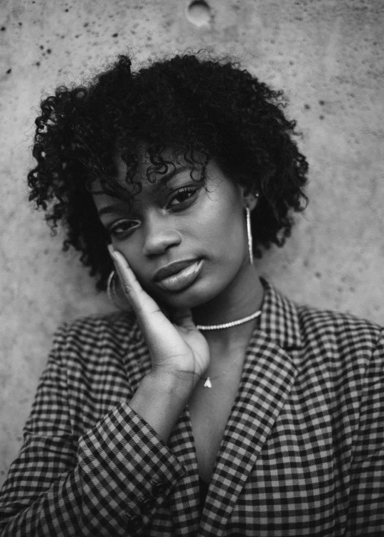 black and white po of a woman wearing a black and white checkered shirt and earrings