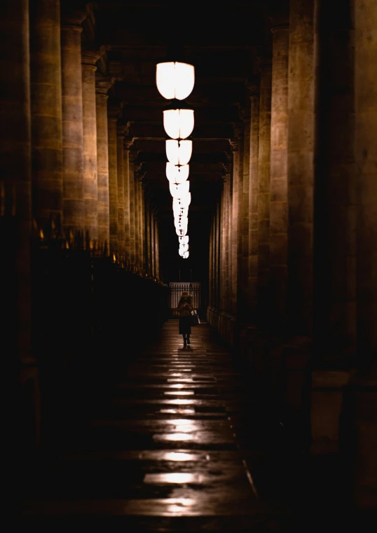 people walking through a dark tunnel with lights