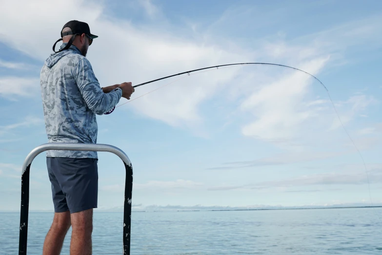 a man fishing on the boat while holding onto a rod