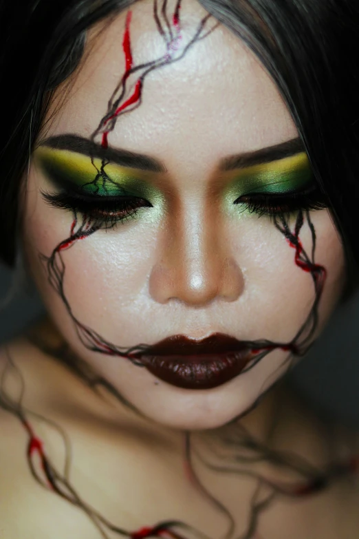 woman with green eye makeup, red makeup and green eyes