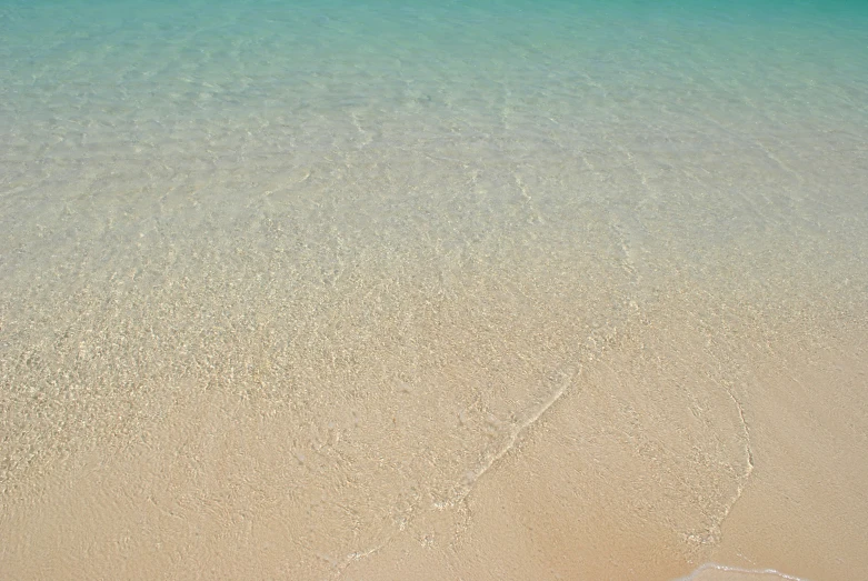 the ocean water with ripples on the beach