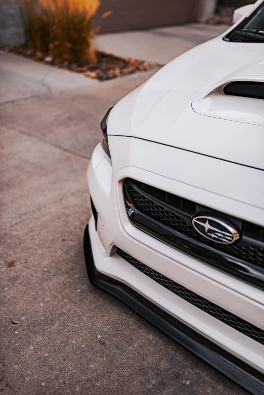 the front end of a white vehicle on a street