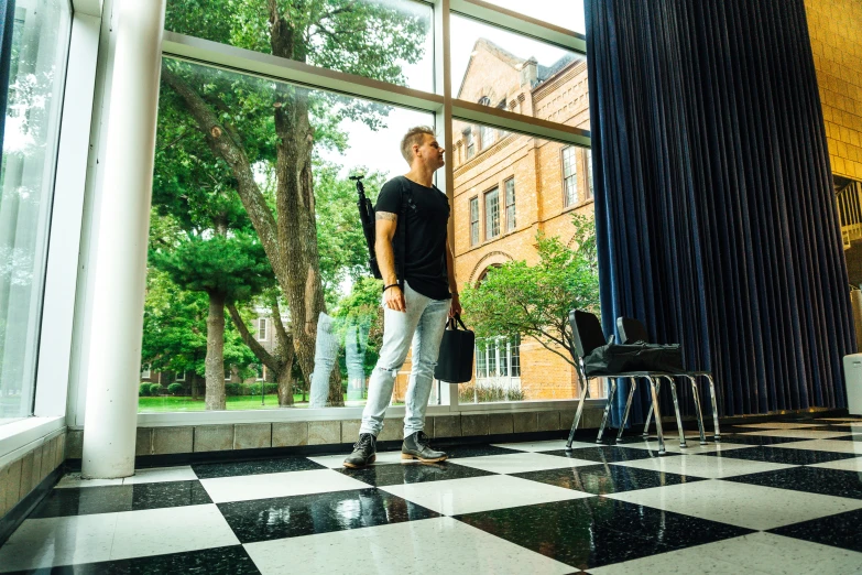 a man standing in a building with a checkered floor