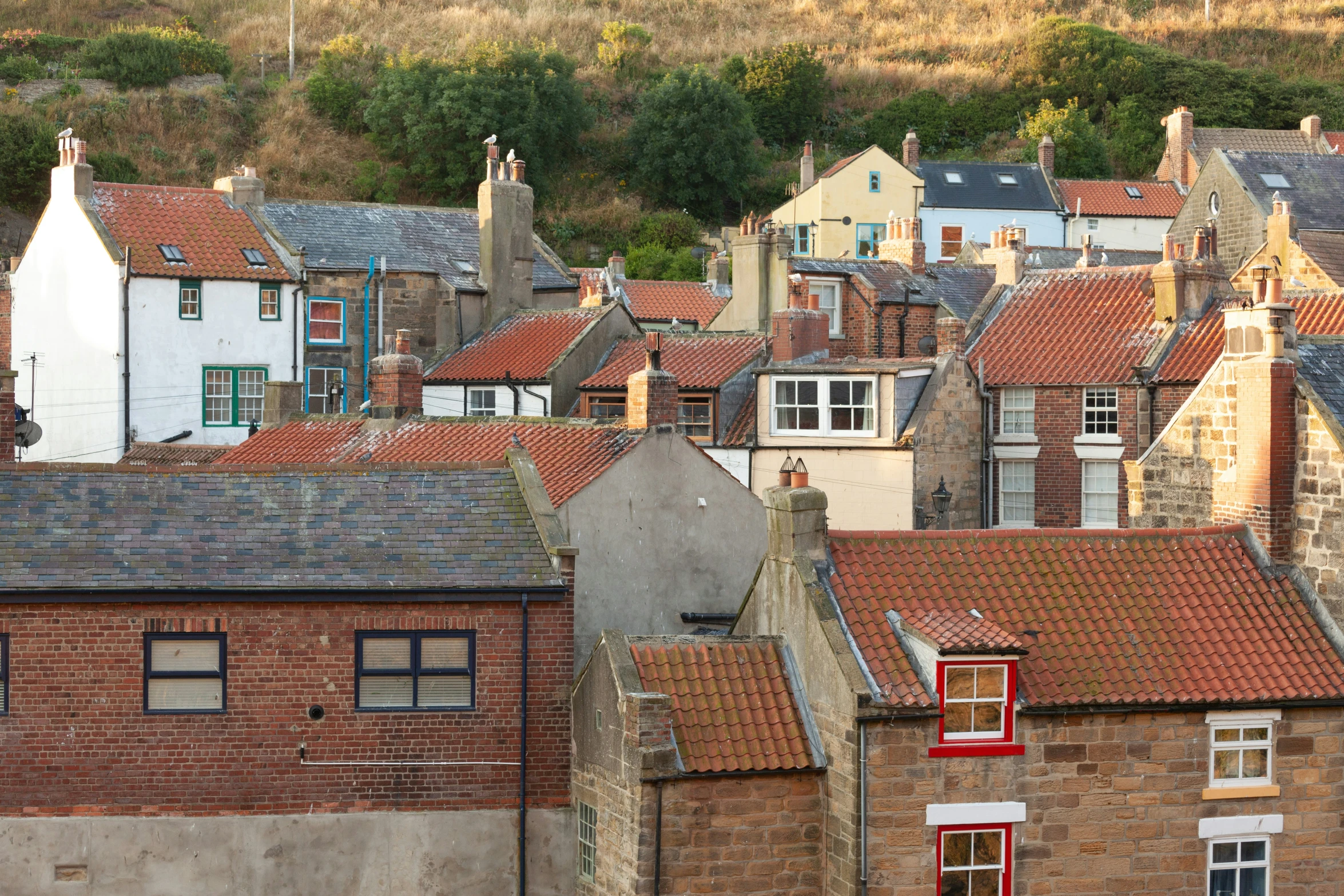 some very pretty red brick buildings by the mountains