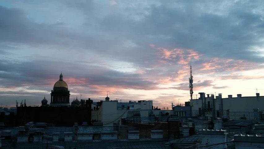 the sun sets over a city skyline and spires