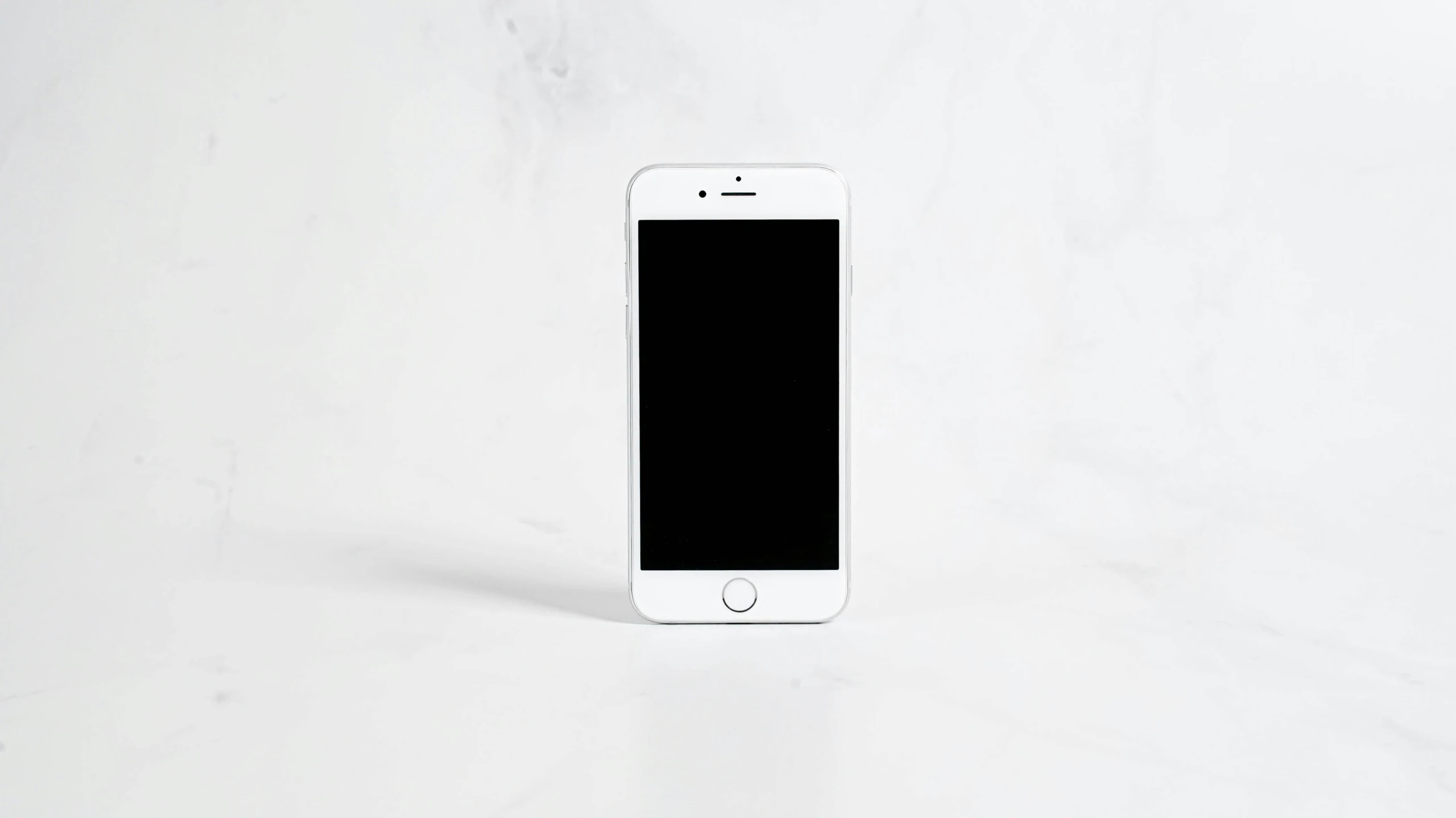 an iphone is sitting on a white surface