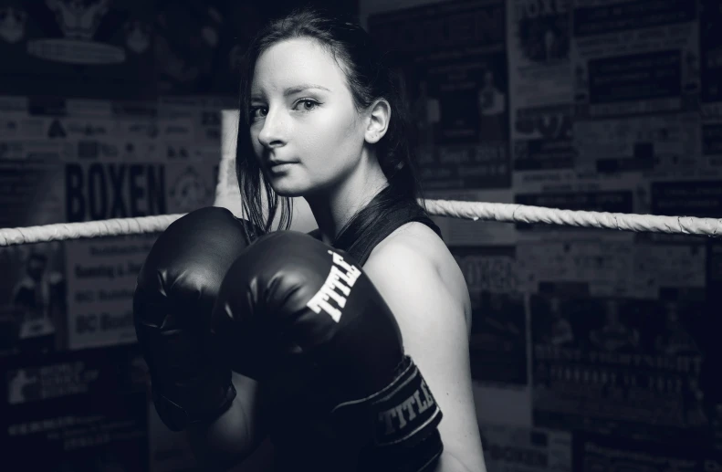 a beautiful young woman posing in a boxing ring