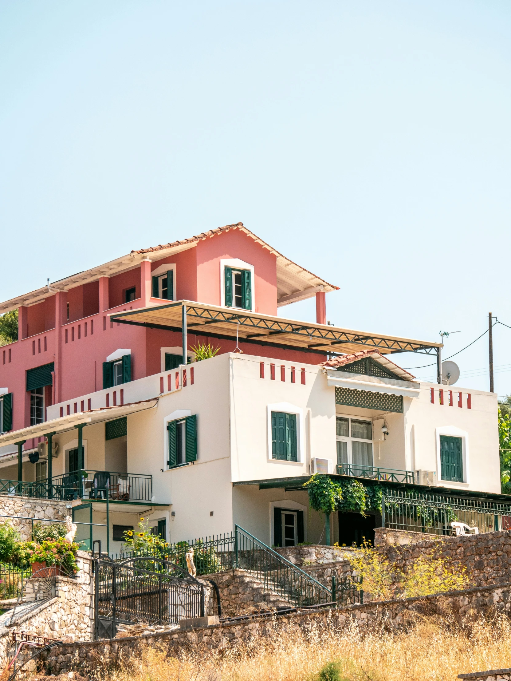 a large pink house has many windows and balconies