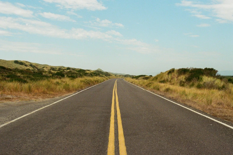 the sky is cloudy and blue above a road