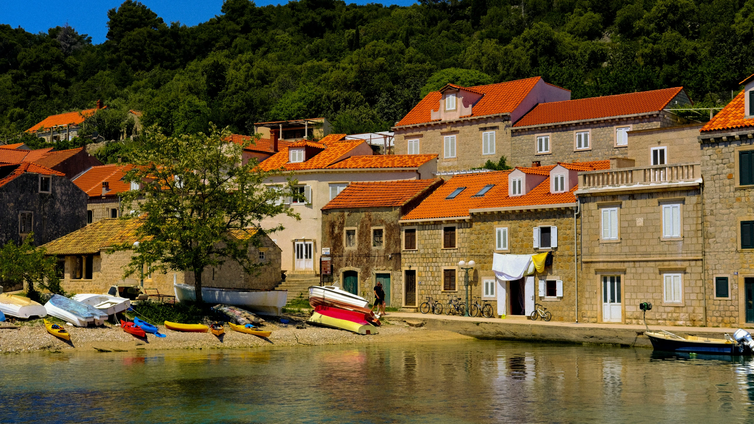 a row of small boats in the water by houses