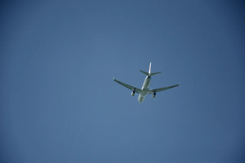 an airplane flying in the air, just after it comes in for landing