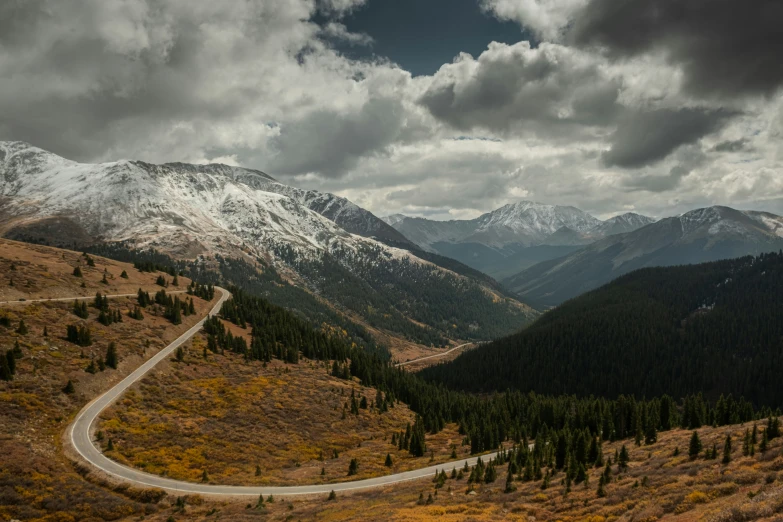 a road that has multiple curves leading into the mountains